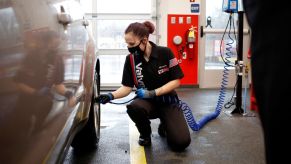 A Valvoline worker checking tire pressure, which is one of 10 bad driving habits to keep an eye on