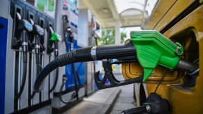 A green gas pump in a vehicle.