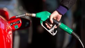 A man filling up his luxury Ferrari vehicle with premium fuel at a petrol gas station in Guildford, U.K.