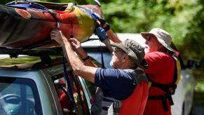 A pair of men taking a kayak off the top of a car's roof rack for the Five Locks Boat Launch at the Schuylkill River