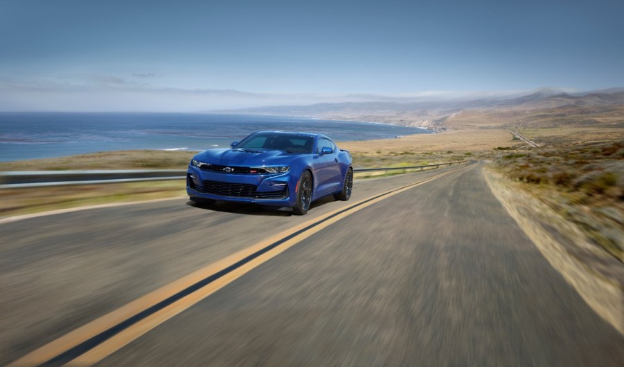 A blue 2022 Chevy Camaro driving down a desert road.