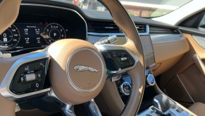 The steering wheel and center console view in the 2022 Jaguar F-Pace S.