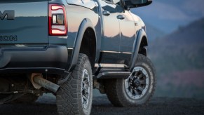 Closeup of a blue-gray Power Wagon pickup truck parked on a mountain pass, trees visible in the distance.