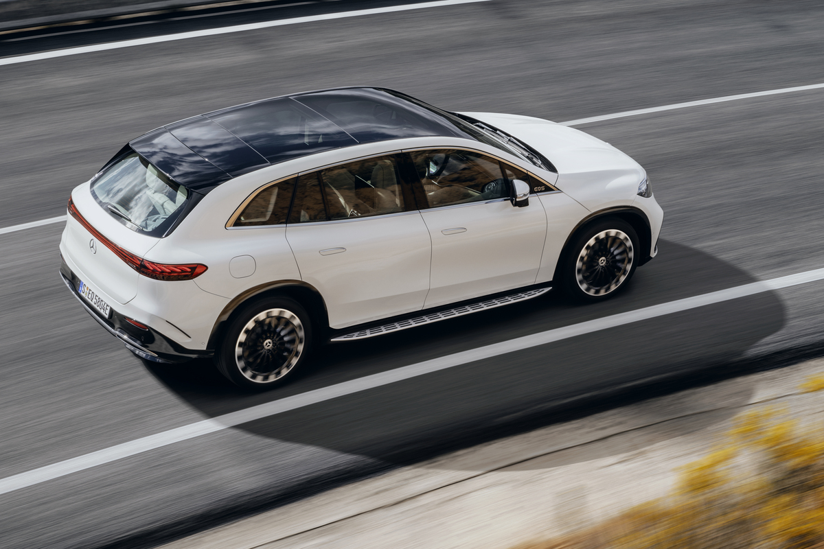 A white EQS SUV on a curving road. 