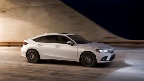 A white 2022 Honda Civic Hatchback model driving through a tunnel