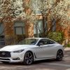 A white 2022 Infiniti Q60 luxury sports coupe model parked on a cobblestone street