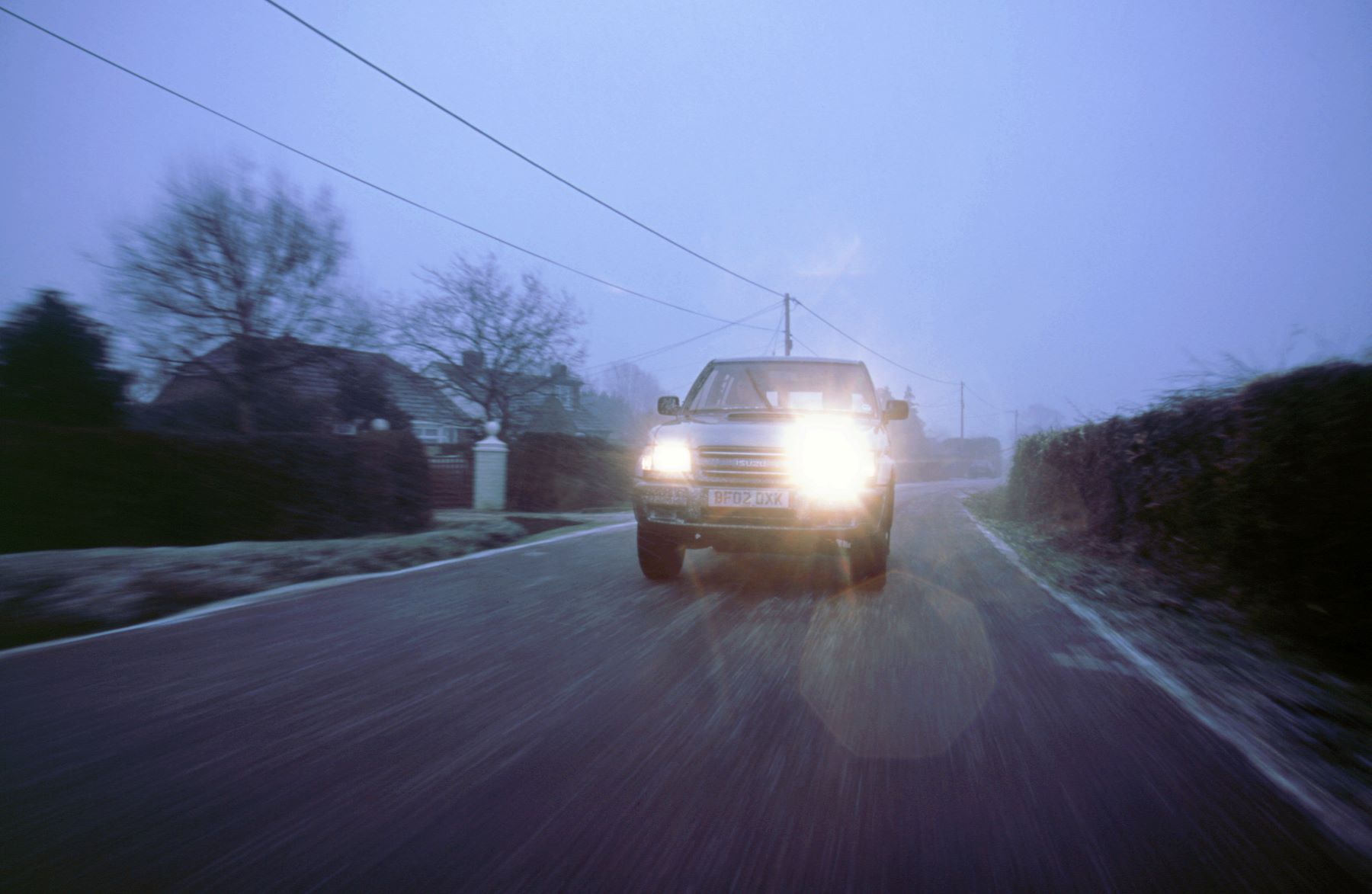 A 2002 Isuzu Trooper Duty with its high beams on, which is a rude gesture on the road