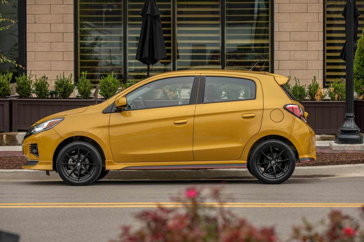 An orange 2022 Mitsubishi Mirage parked in front of a business, the Mirage is one of the cheapest new cars on the road today