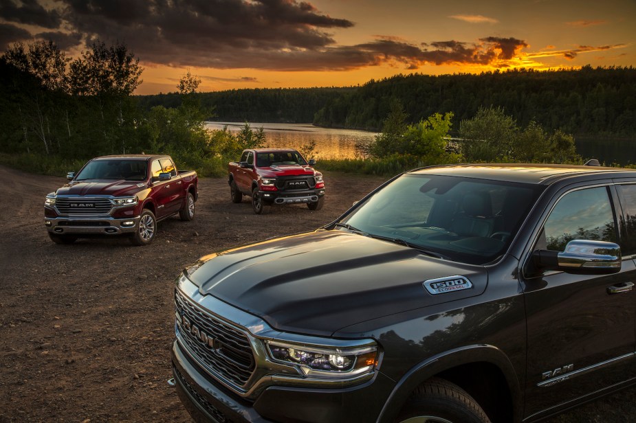 Promo photo of several Ram 1500 pickup trucks with the EcoDiesel V6, a sunset over a pond visible in the background.