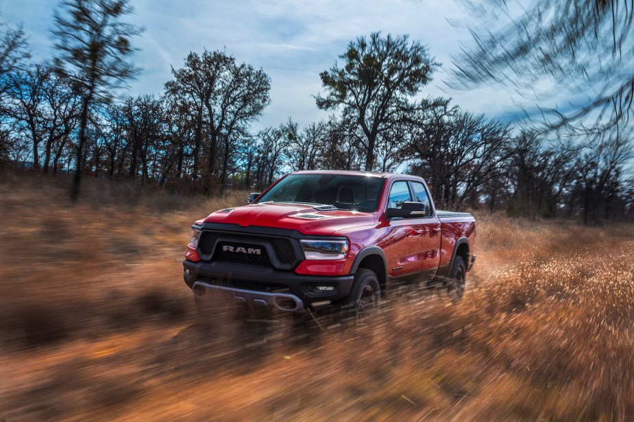 The Ram 1500 Rebel with TRX appearance package and a naturally-aspirated V8 in red, racing along an off-road trail.