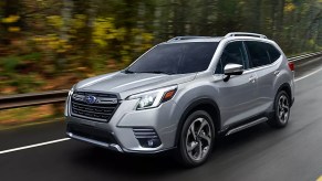 A gray Subaru Forester small SUV is driving on the road.