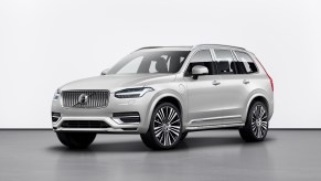 Promo photo of a silver Volvo XC90 midsize SUV with a 3rd row of seating and a plug-in hybrid drivetrain.