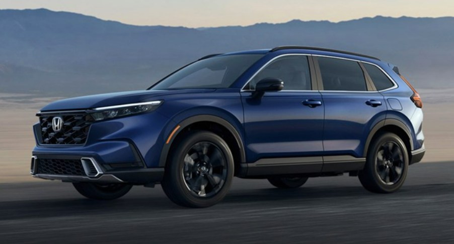 A blue 2023 Honda CR-V small SUV is driving on the road.