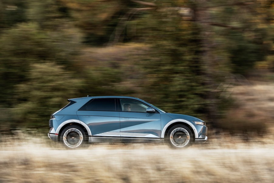 A 2023 Hyundai Ioniq 5 EV SUV driving alongside of a field