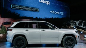 A white 2023 Jeep Grand Cherokee parked indoors.