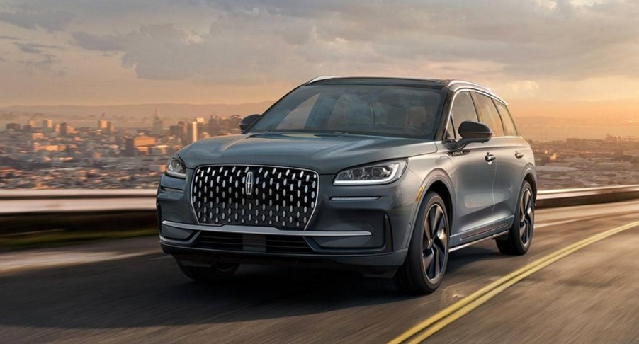 A gray 2023 Lincoln Corsair small luxury SUV is driving on the road.