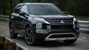 A black 2023 Mitsubishi Outlander PHEV is parked.