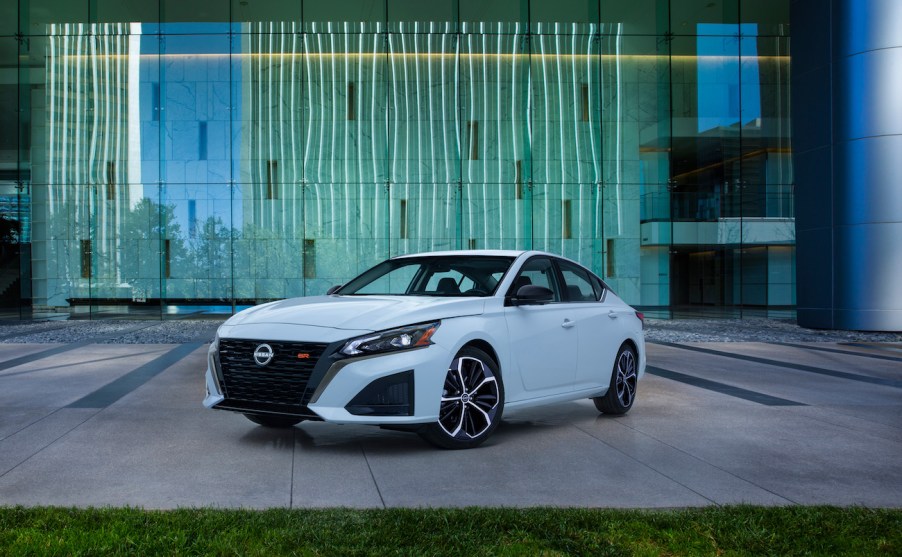 A white 2023 Nissan Altima sitting in front of a building.