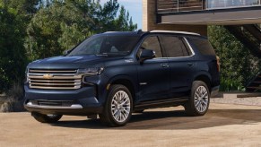 A navy blue 2023 Chevy Tahoe parked outside of a house.