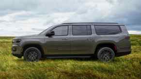 A gray 2023 Jeep Wagoneer L parked in a field. The longer wheelbase is one reason it's worth waiting for.