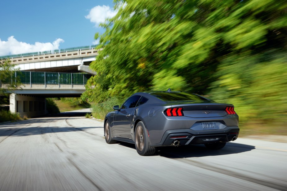 The rear view of a 2024 Ford Mustang driving on a freeway.