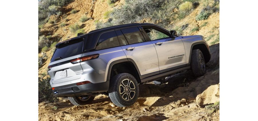 A silver Jeep Grand Cherokee 4xe Trailhawk on dirt.