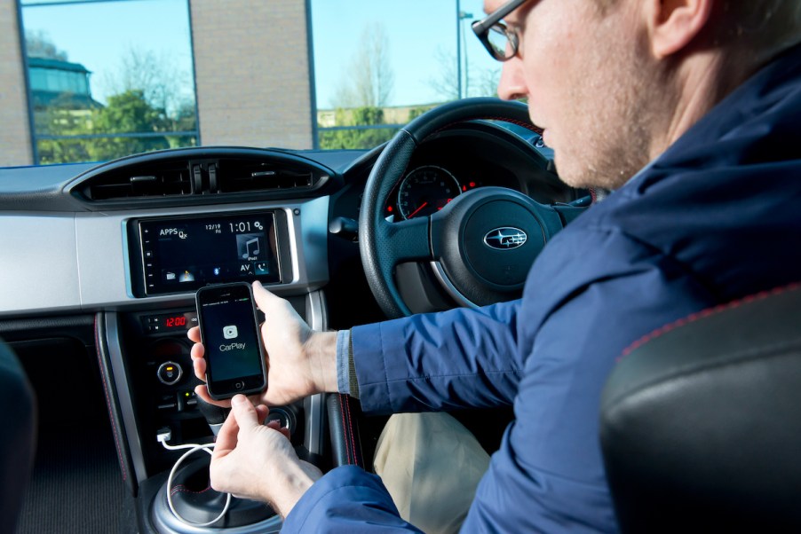 A person connected with Apple CarPlay via a cord and not through an Apple CarPlay wireless adapter.