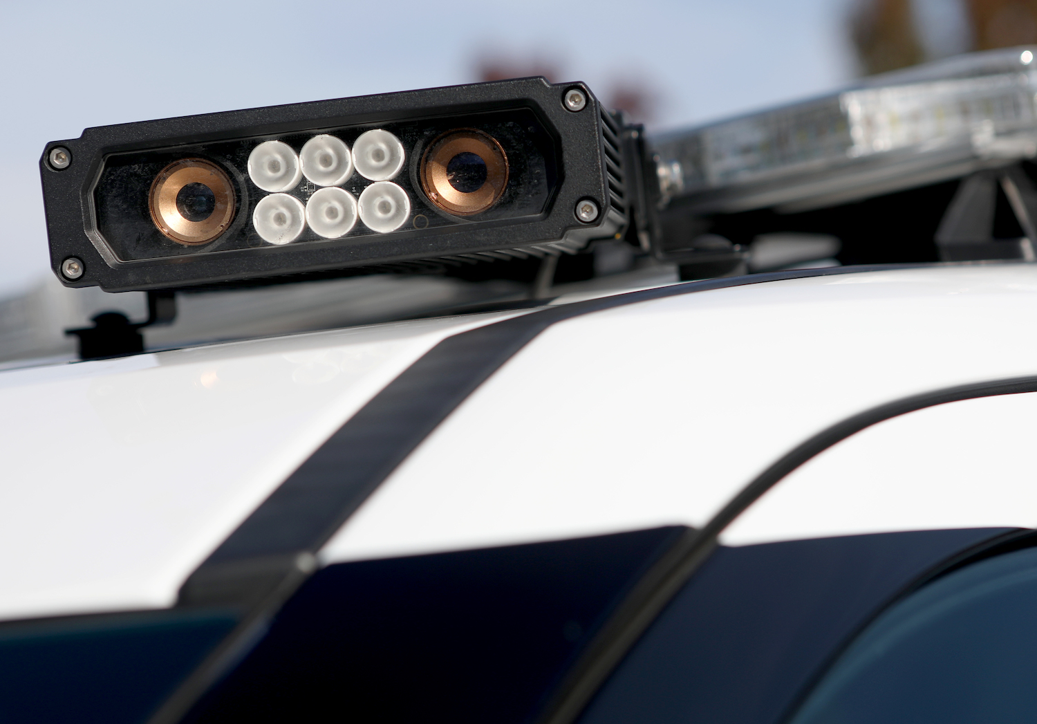 Closeup of an automatic license plate reader scanner camera on the roof of a police SUV.