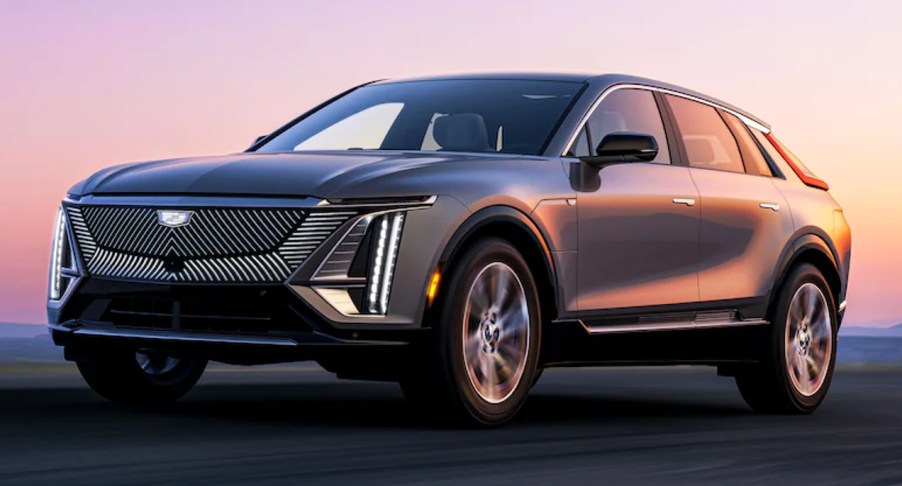 A gray 2023 Cadillac Lyriq midsize electric SUV is driving on the road.