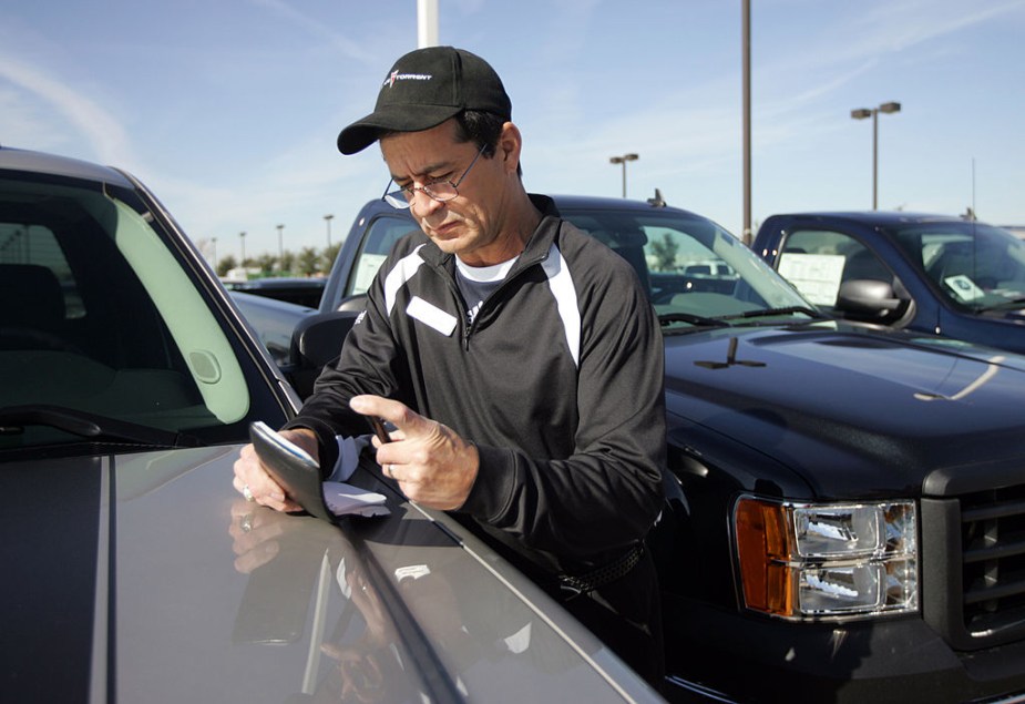 A pre-owned car salesman checks the VIN number on a pre-owned car at Classic Buick-Pontiac-GMC.