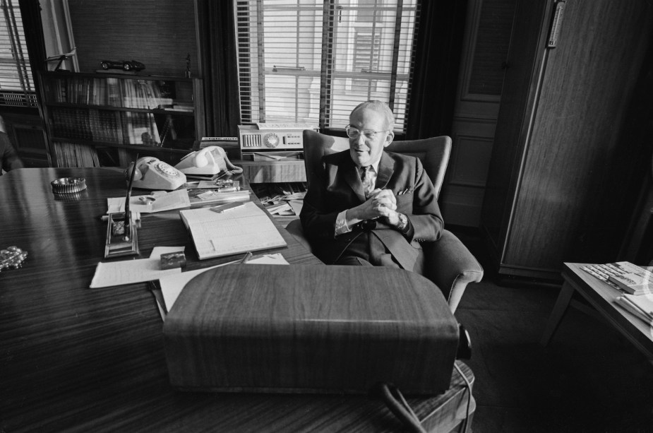 Aston Martin company owner David Brown sitting behind his desk for a publicity portrait in 1968.