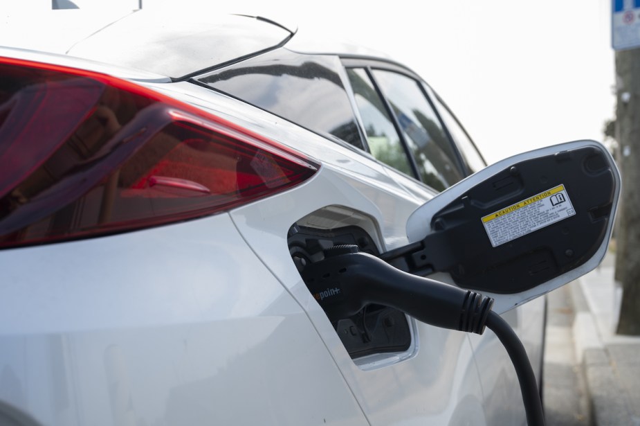 A white EV charging outdoors. 