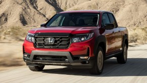 Front angle view of Radiant Red Metallic 2023 Honda Ridgeline pickup truck