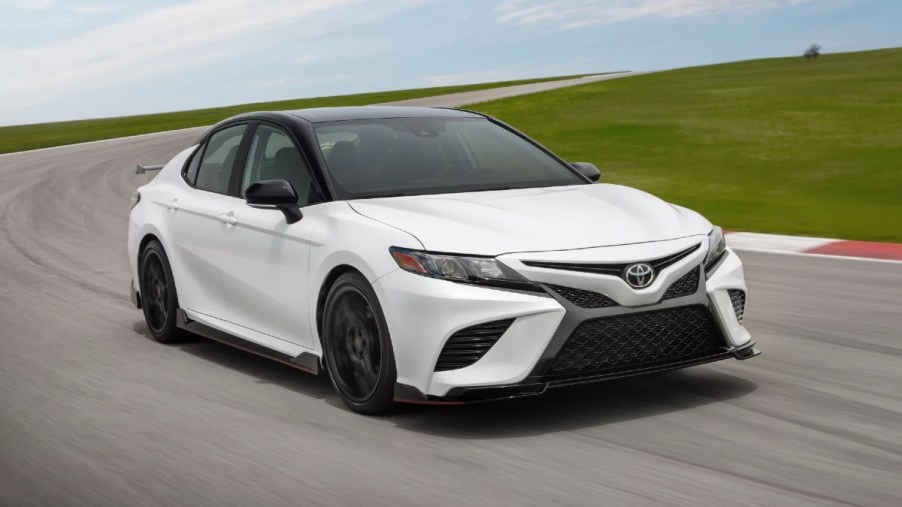 Front angle view of new white 2023 Toyota Camry midsize sedan, highlighting how much a fully loaded version costs