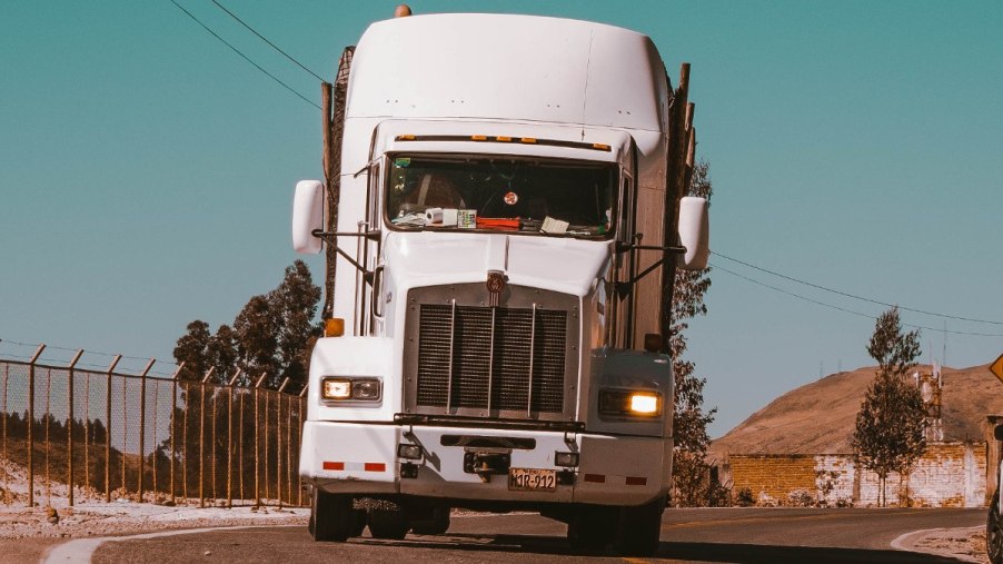 Front view of white semi-truck, highlighting why trucks have to stop at weigh stations