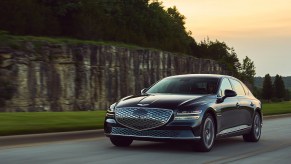 A Genesis Electrified G80 driving at dusk