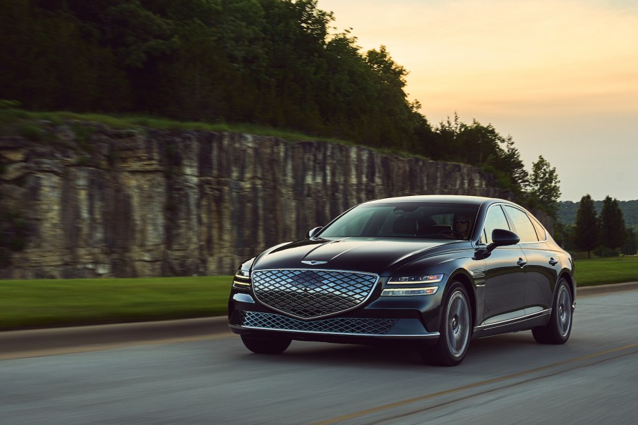 A Genesis Electrified G80 driving at dusk