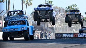 Three stadium super trucks jumping