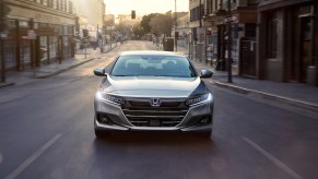 A silver Honda Accord Hybrid driving in a city