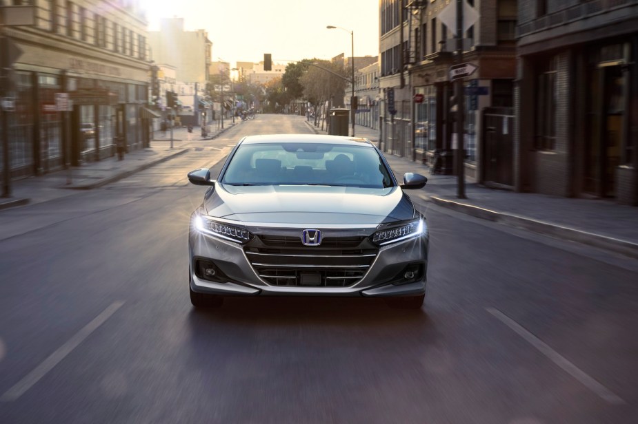 A silver Honda Accord Hybrid driving in a city, the Honda Accord is among the most popular cars in America