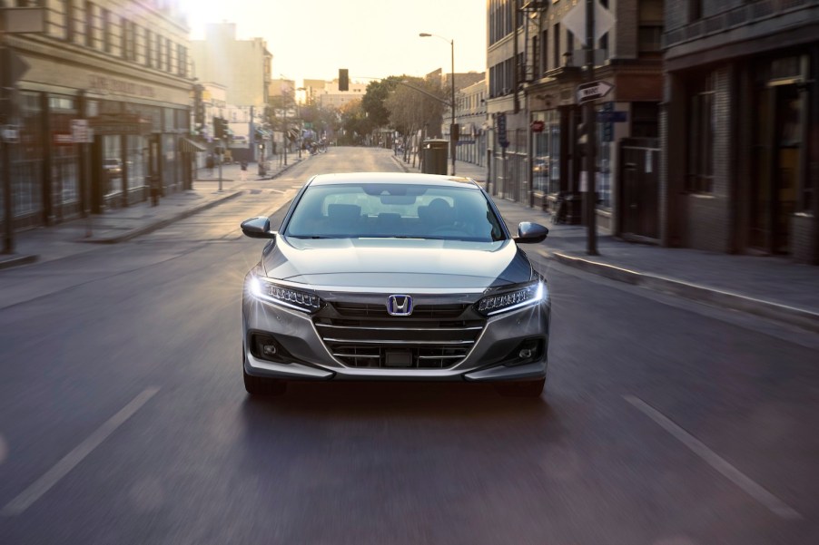 A silver Honda Accord Hybrid driving in a city