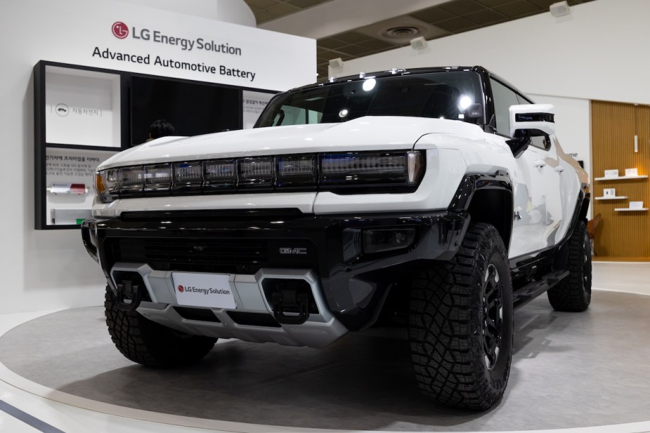 A white GMC Hummer parked indoors. 