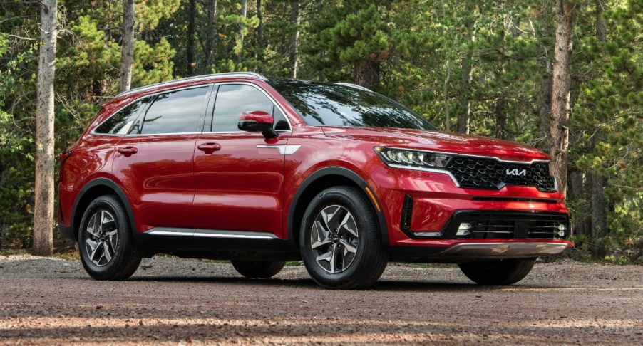 A red Kia Sorento Hybrid midsize hybrid SUV is parked.