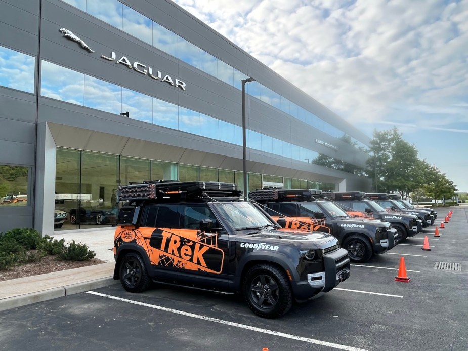 A row of kitted-out Land Rover Defender 110s in front of Jaguar Land Rover HQ.