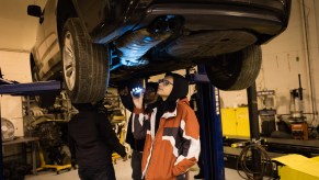 A person potentially checking to see if a car is leaking.