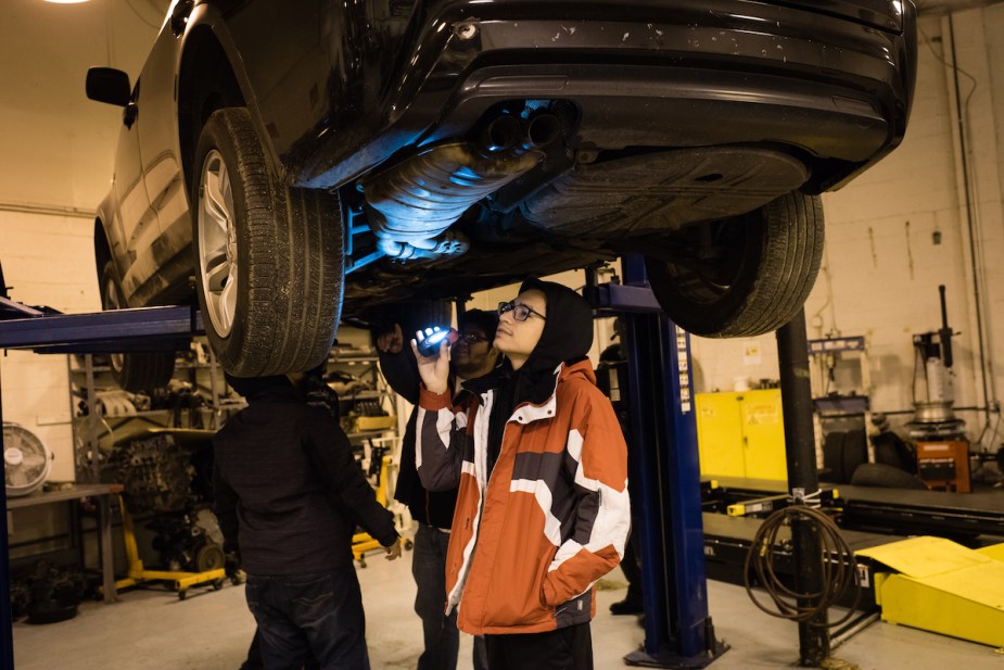 A person potentially checking to see if a car is leaking.