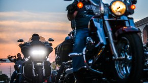 People sharing the road with motorcycles as they drive down the road.