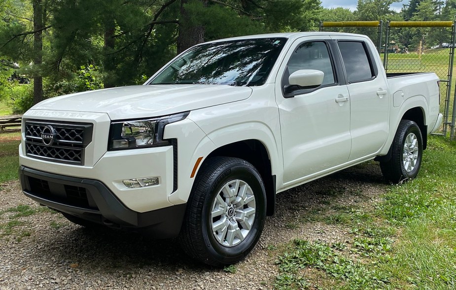 A white 2022 Nissan Frontier SV sits in a field.