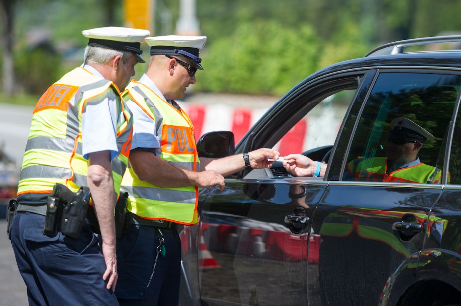 Police pulling over a car that potentially don't have insurance. 