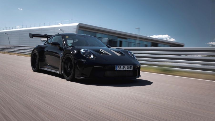 A black Porsche AG 911 GT3 RS model on a racetrack